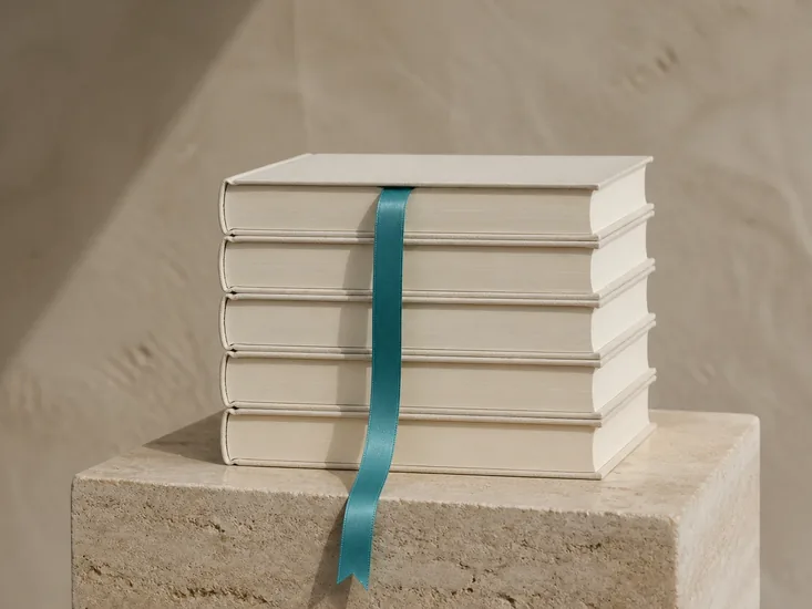 Five identical volumes stacked in studio light